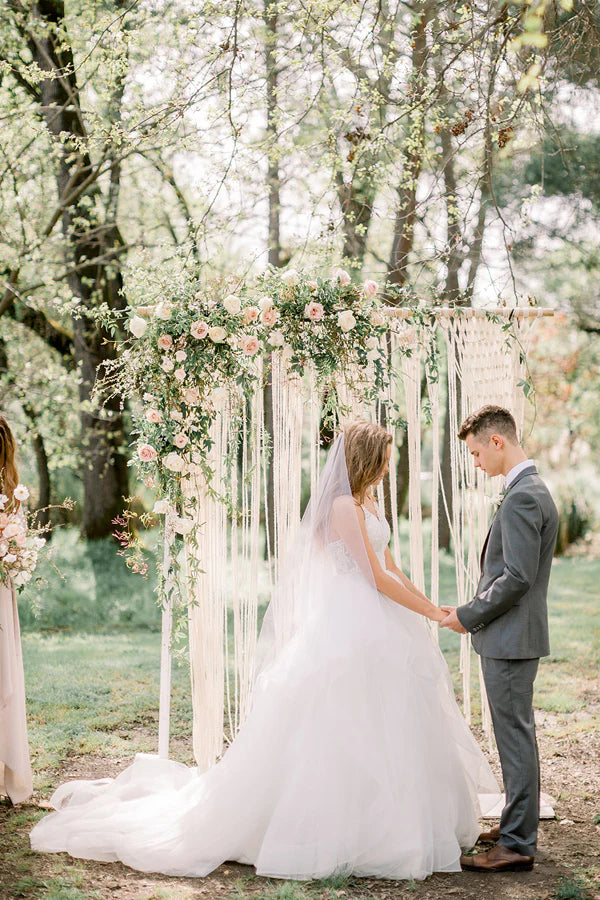 Bride walking in A-line V-neck wedding dress in a natural setting.