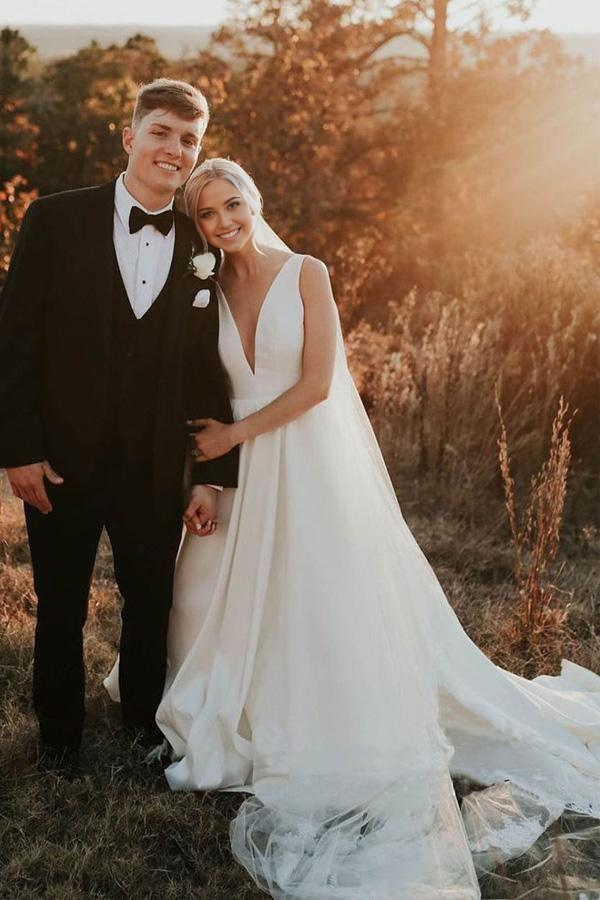 Side profile of a simple ivory satin V-neck wedding dress.