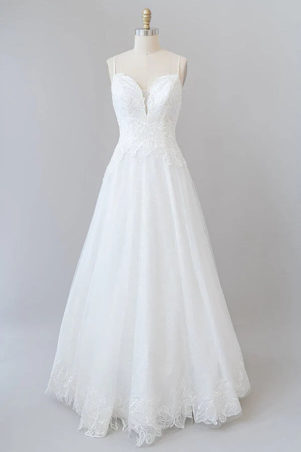 Elegant A-line tulle wedding dress with spaghetti straps.