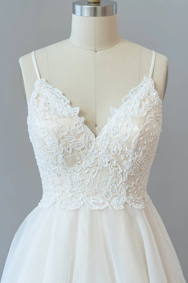 Close-up of the lace bodice and spaghetti straps on the wedding gown.