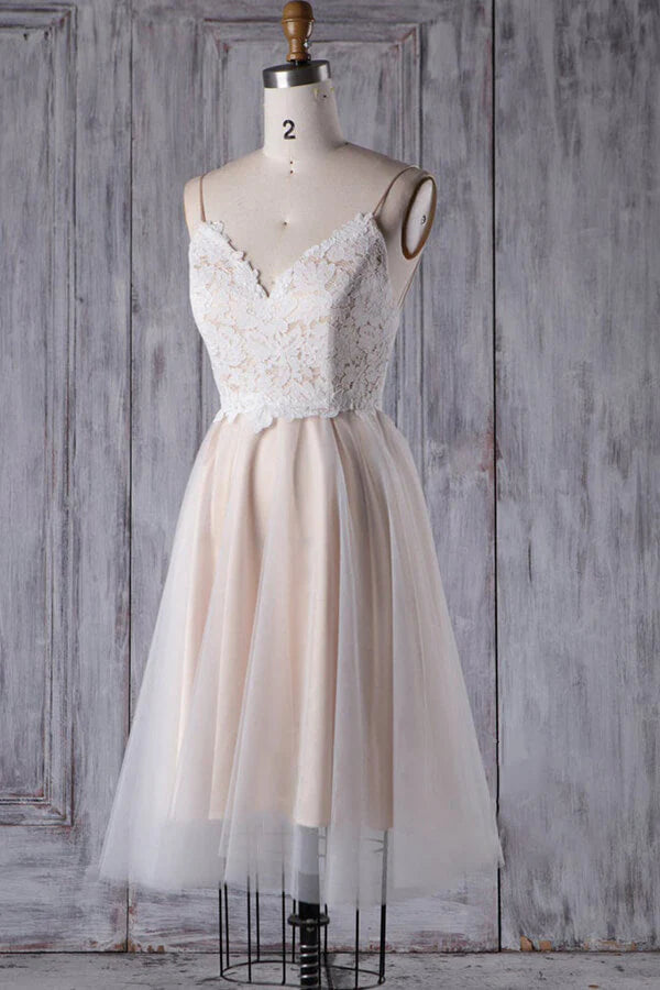 Side profile of a bride wearing a short lace and tulle wedding dress.