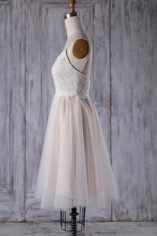 Close-up of the lace bodice and spaghetti straps on a short wedding dress.