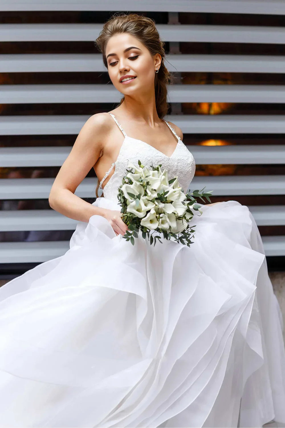 Close-up of the lace top and spaghetti straps on a wedding dress.
