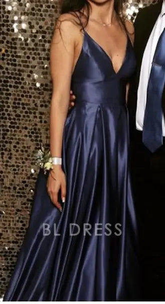 Back view of a model in a navy blue V-neck evening gown.