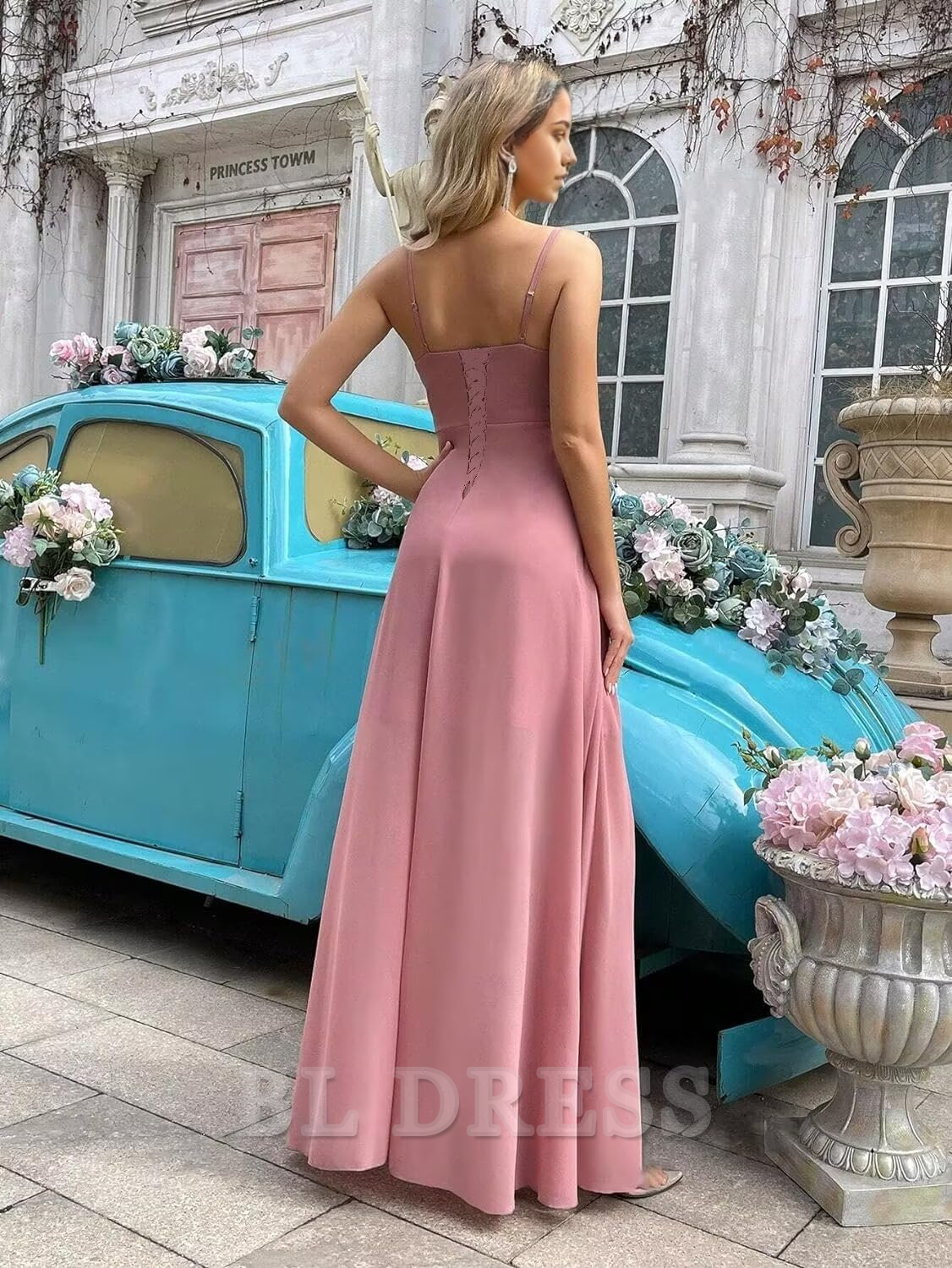 Back view of a woman wearing a light blue A-line formal dress with delicate spaghetti straps.
