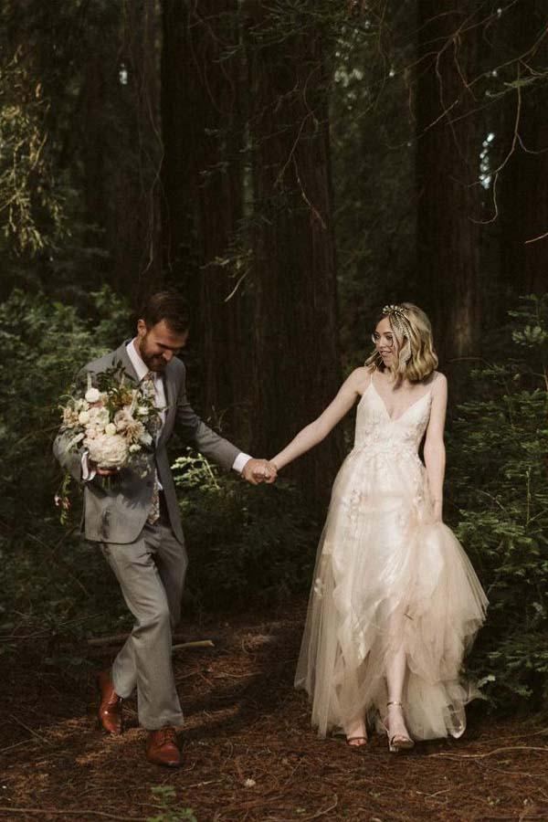 Elegant A-line V-neck wedding dress with spaghetti straps and lace applique.