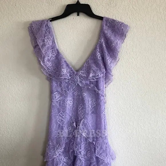 Close-up of the intricate tiered lace fabric on the lilac dress.