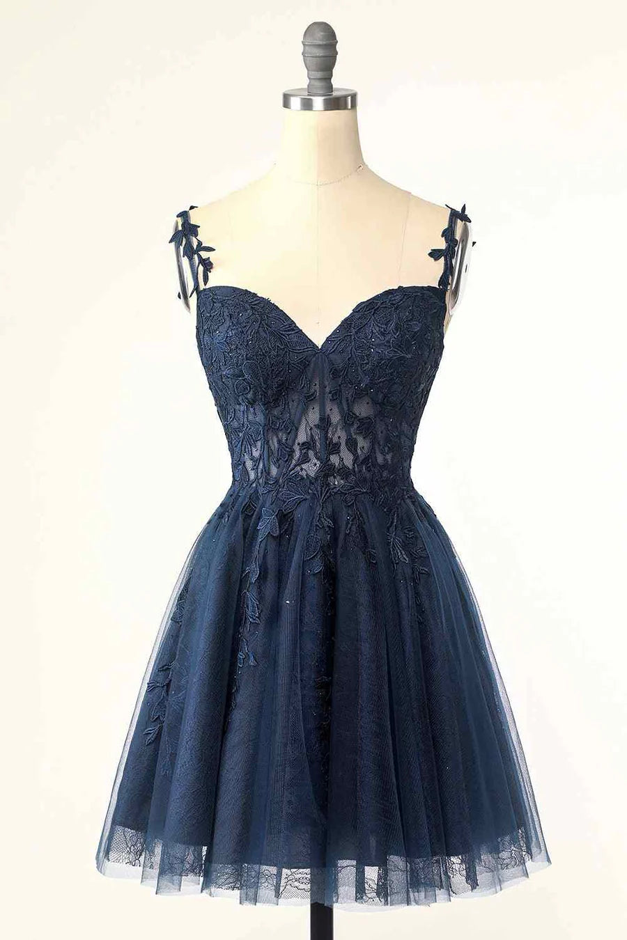 Model wearing an elegant A-line V-neck tulle homecoming dress with floral appliques.