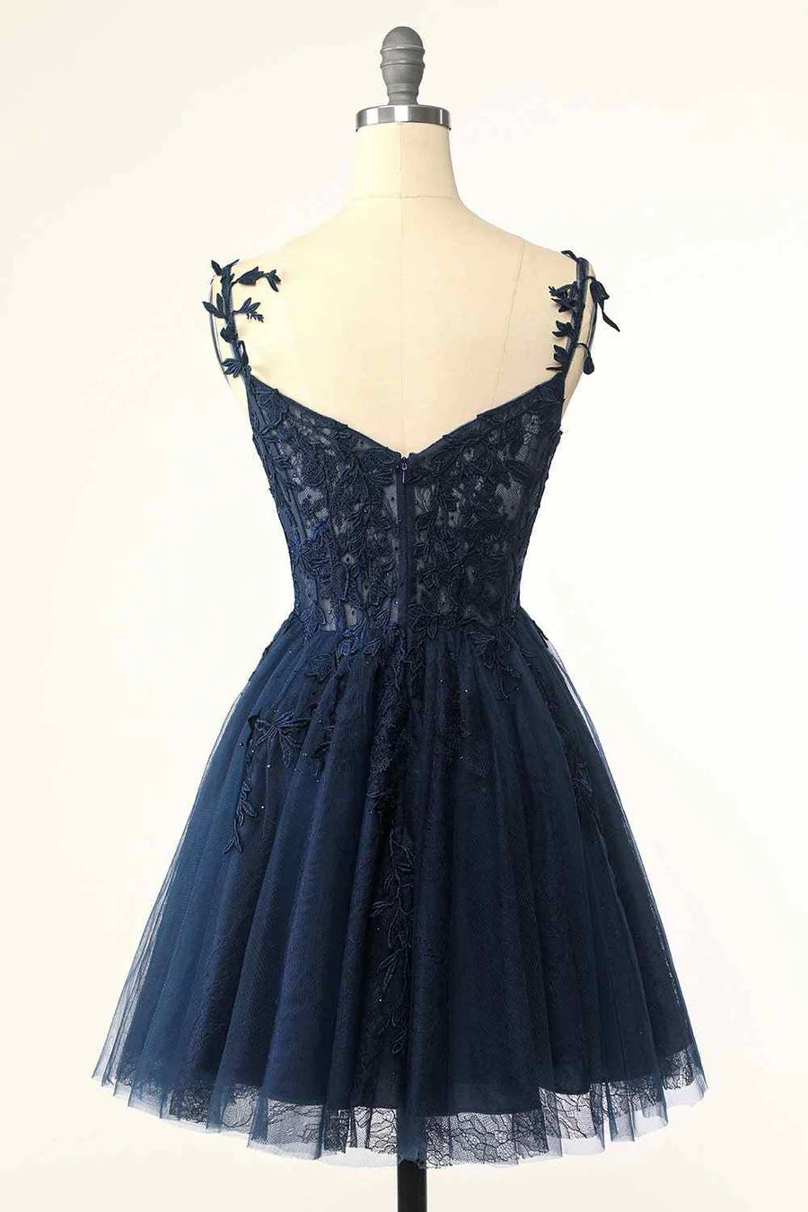 Close-up of the delicate floral appliques and V-neckline on the tulle dress.