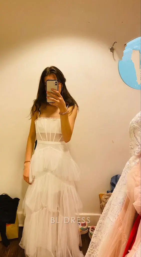 Woman wearing an elegant white A-line V-neck tulle formal dress.