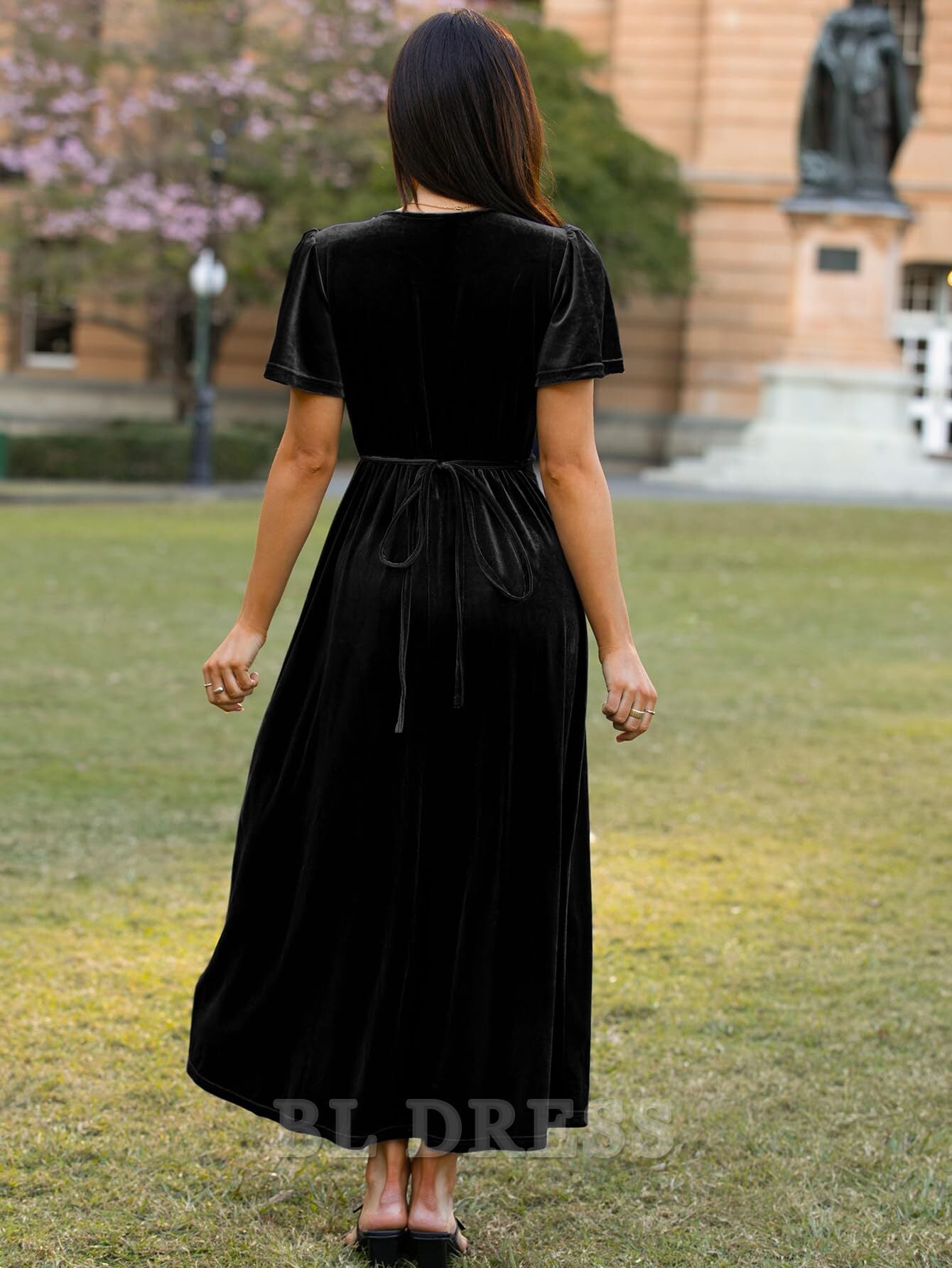 Side view of a woman wearing a deep red velvet formal dress.