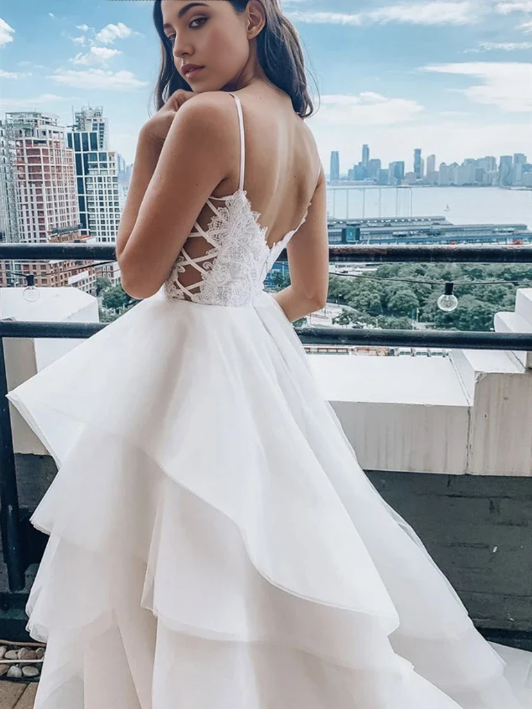 Full view of a white lace A-line bridal gown with V-neckline.