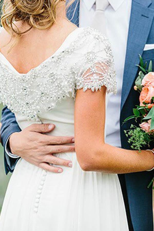 Close-up of the beaded V-neckline on an A-line chiffon wedding dress.