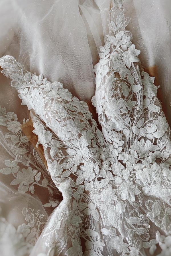 Side profile of a princess A-line wedding gown with lace details.