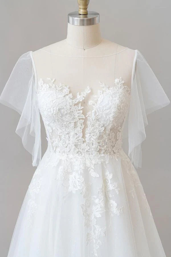 Bride wearing A-line lace and tulle wedding dress with long sleeves.