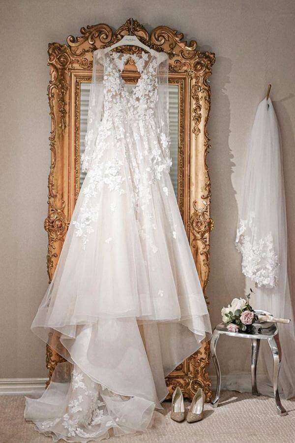 Close-up of the V-neckline and long sleeves on an ivory A-line wedding dress.