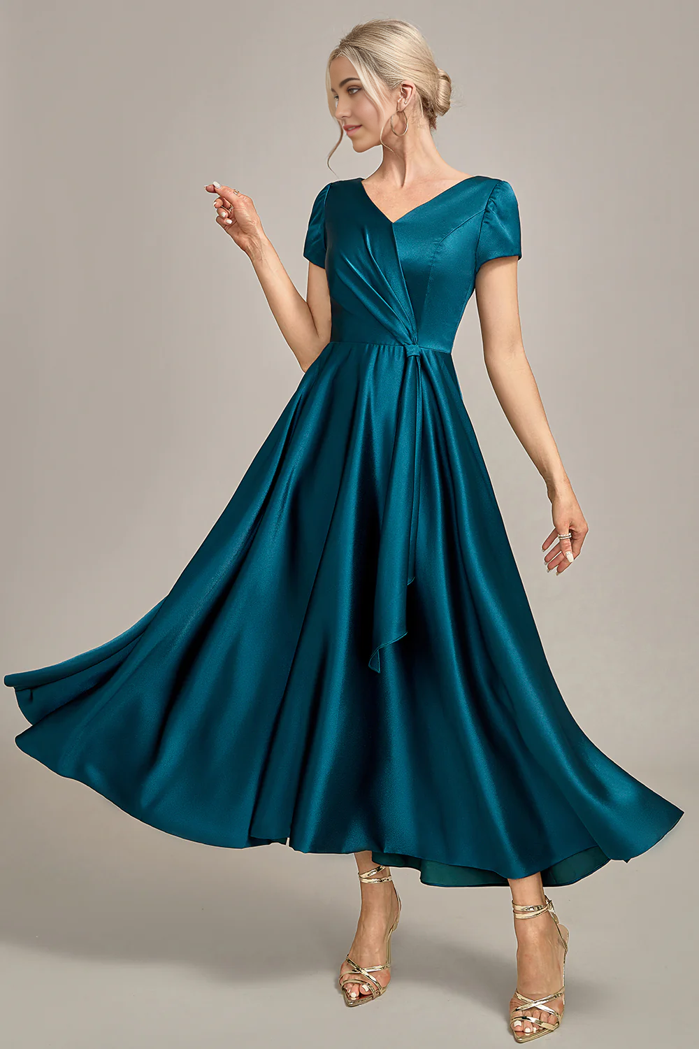 Close-up of the pleated satin fabric on the peacock blue dress.