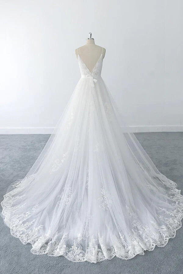 Close-up of the V-neckline and delicate ruffle appliques on the wedding dress.
