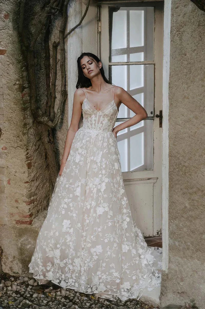 A-line V-neck wedding gown with lace appliques and straps.
