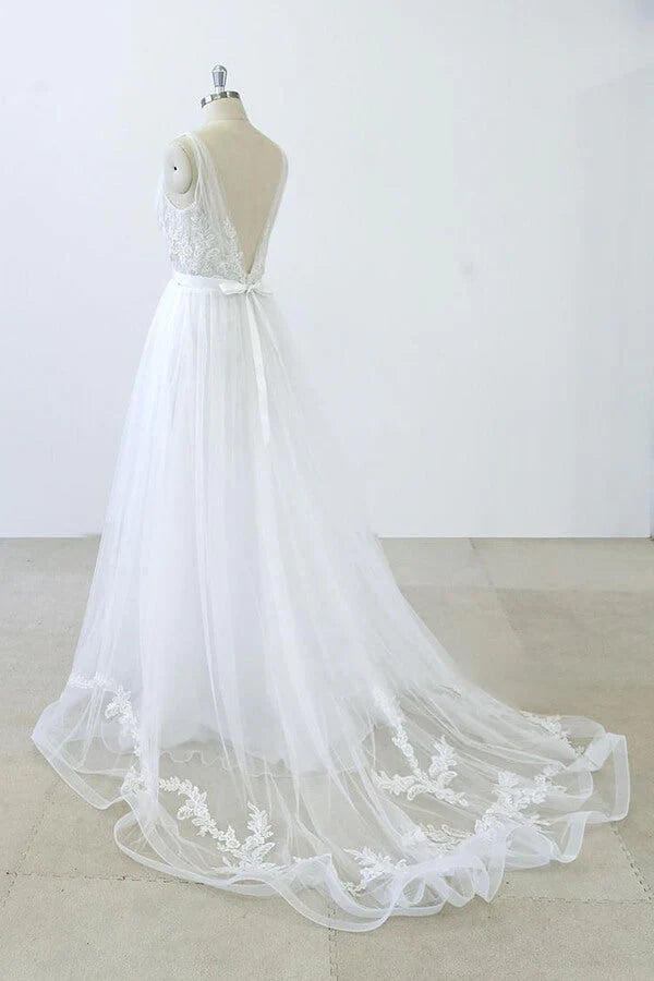 Detail of the V-neck sweetheart neckline and ruffle appliques on a bridal gown.