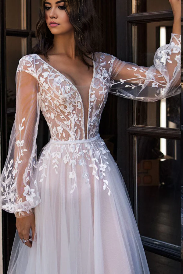 Close-up of V-neck bodice and long lace sleeves on wedding gown.
