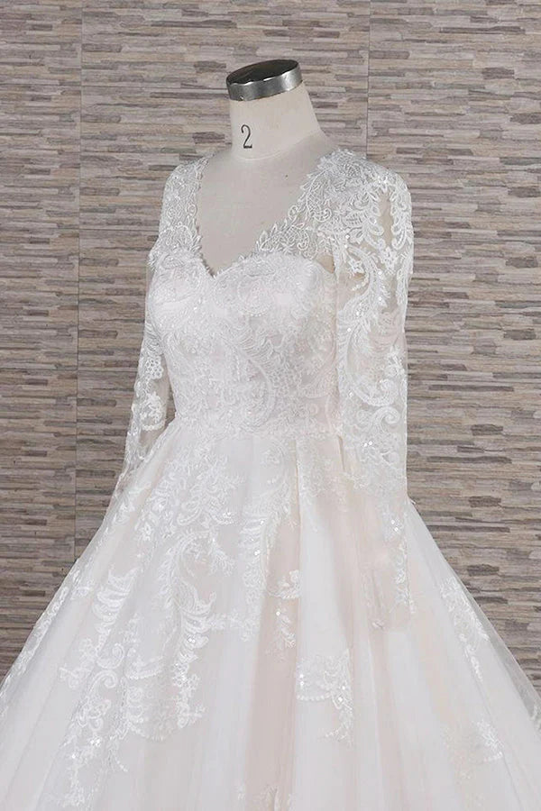 Close-up of lace appliques on the long sleeve of a wedding dress.