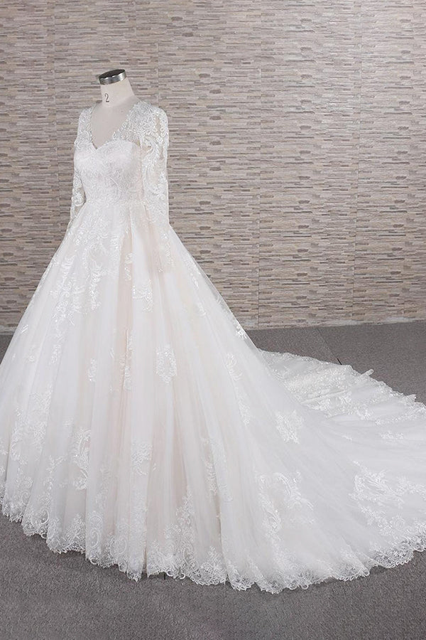 Side profile of a bride in a tulle and lace wedding gown.