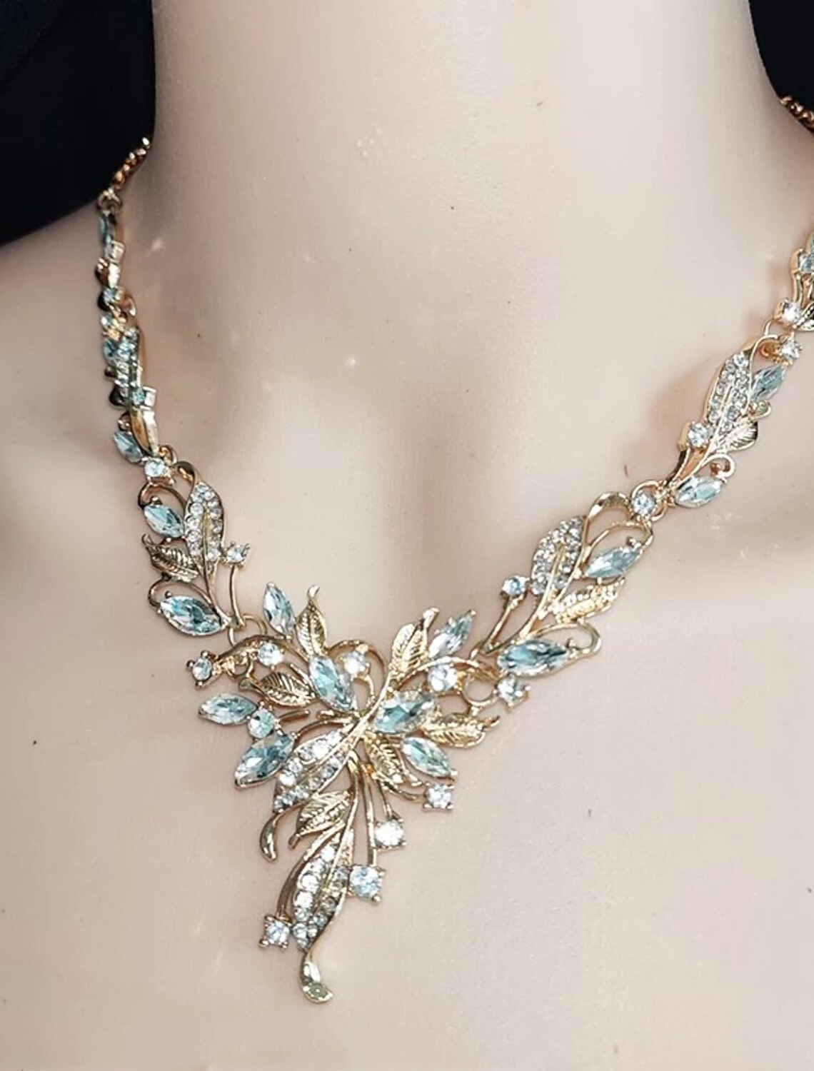 Close-up of a woman wearing a sparkling alloy necklace and earrings.