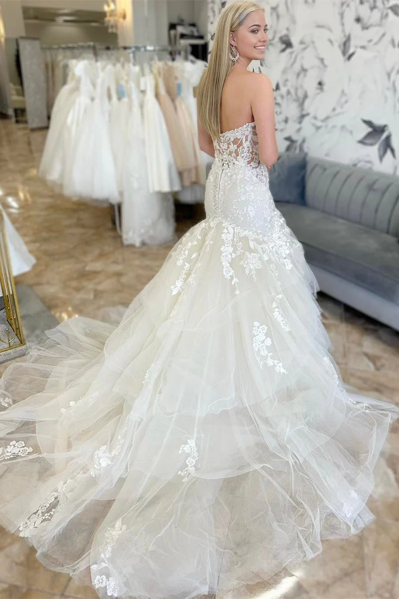 Mermaid trumpet wedding gown featuring multi-layer skirt and appliques.