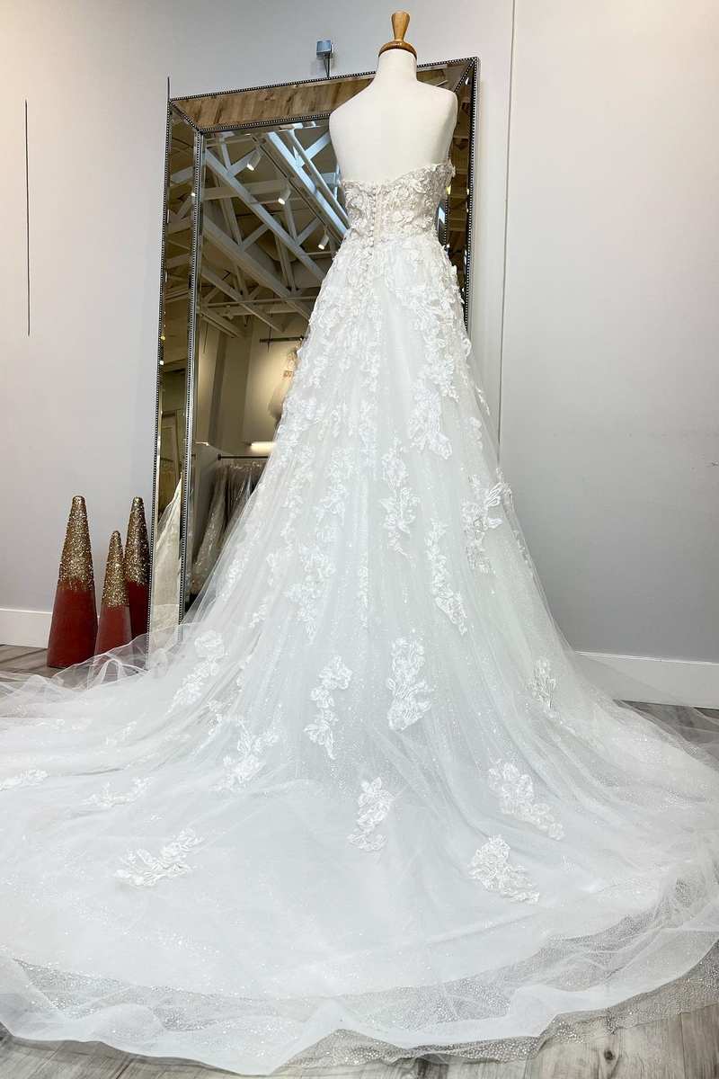 Side view of the applique wedding gown, showcasing the long sweeping train.