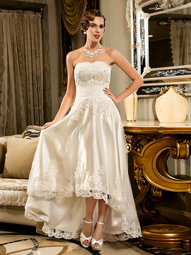 Side view of the white asymmetrical A-line wedding dress, showing lace details.