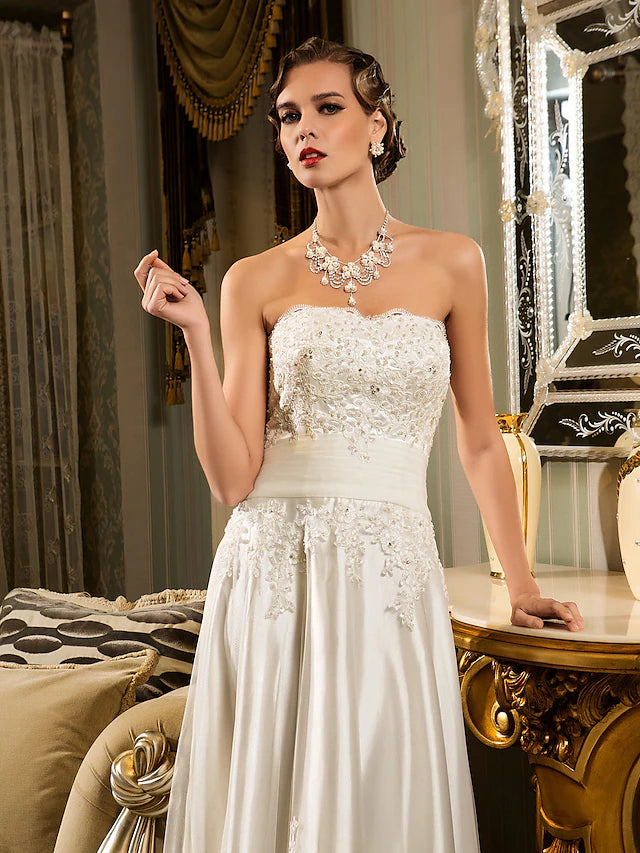 Close-up of the lace and applique details on the white wedding dress.