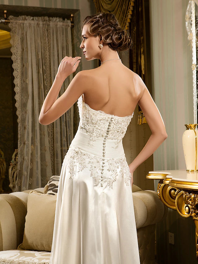 Back view of the white asymmetrical A-line wedding dress with button closure.