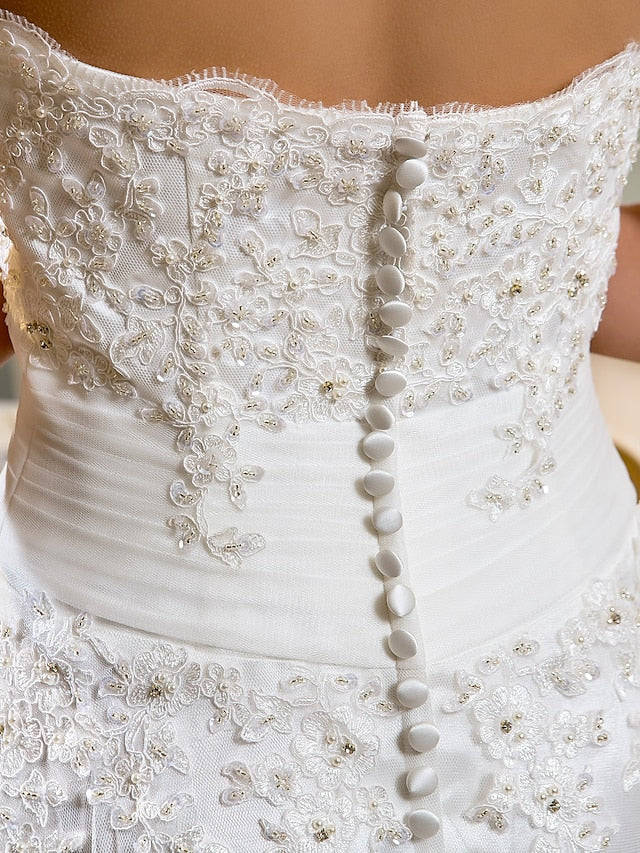 Another angle of the white lace wedding dress, highlighting the asymmetrical hem.