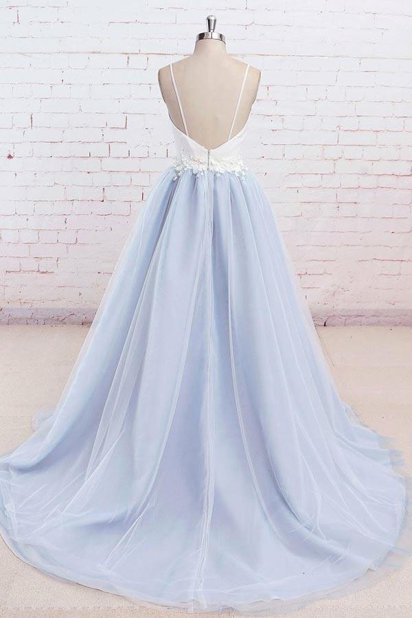 Rear view of a backless tulle prom gown with a flowing sweep train.