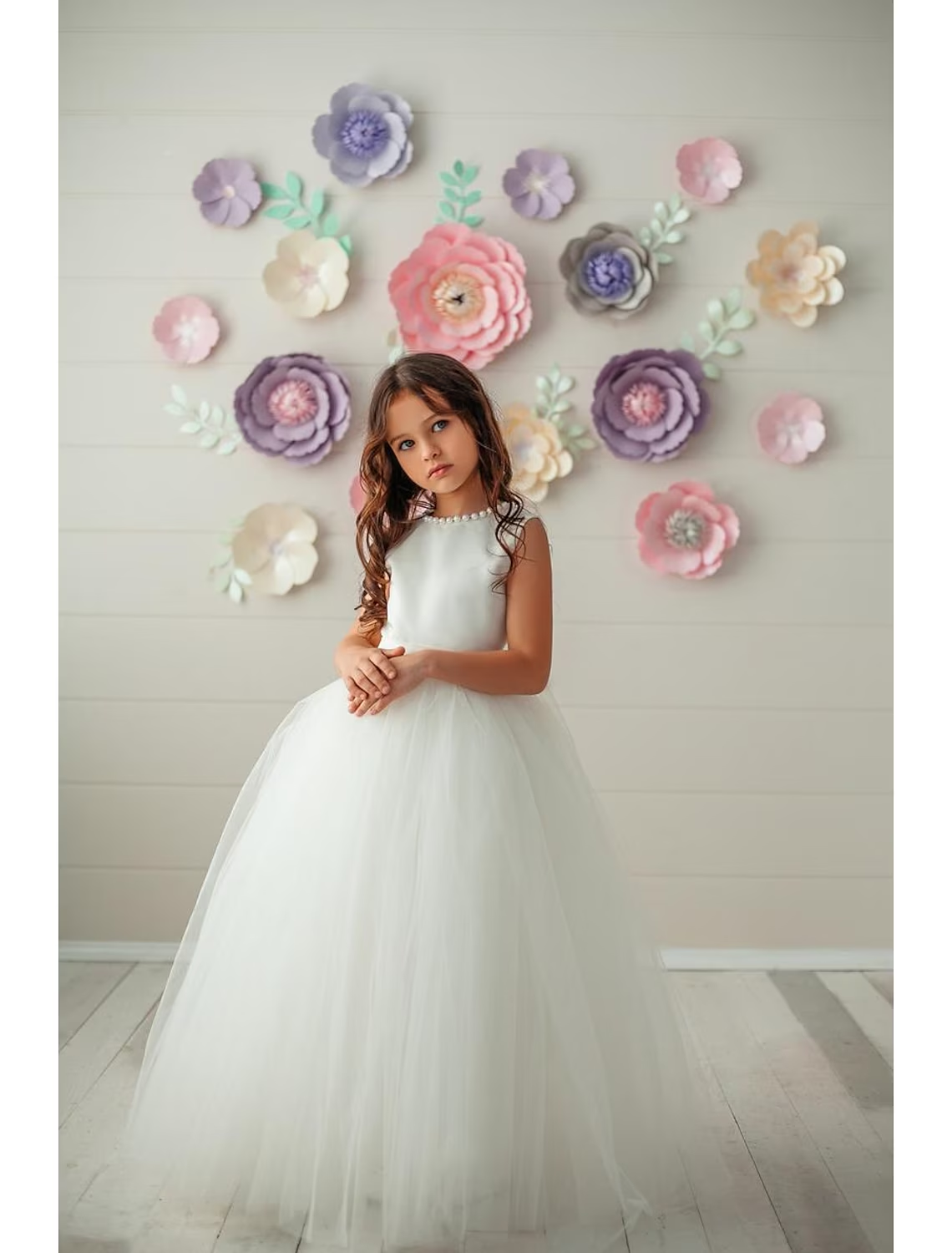 Front view of an elegant satin ball gown flower girl dress with a round neck.