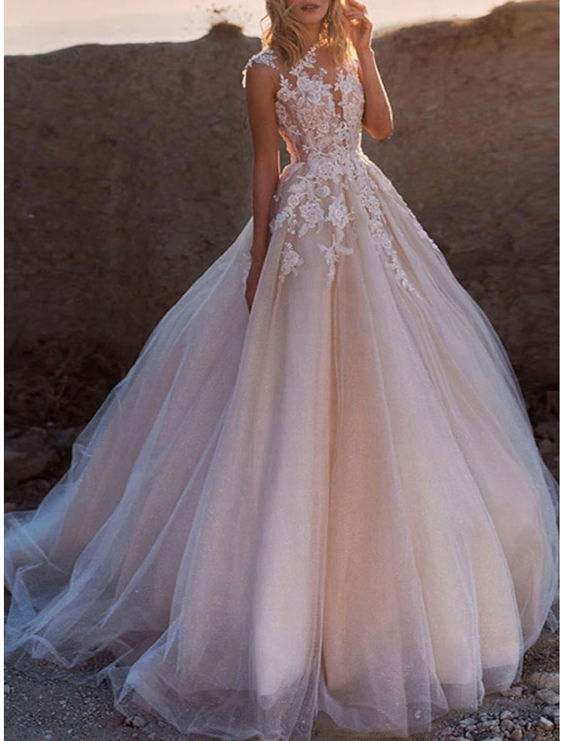 Elegant white ball gown wedding dress with illusion neck and cap sleeves.