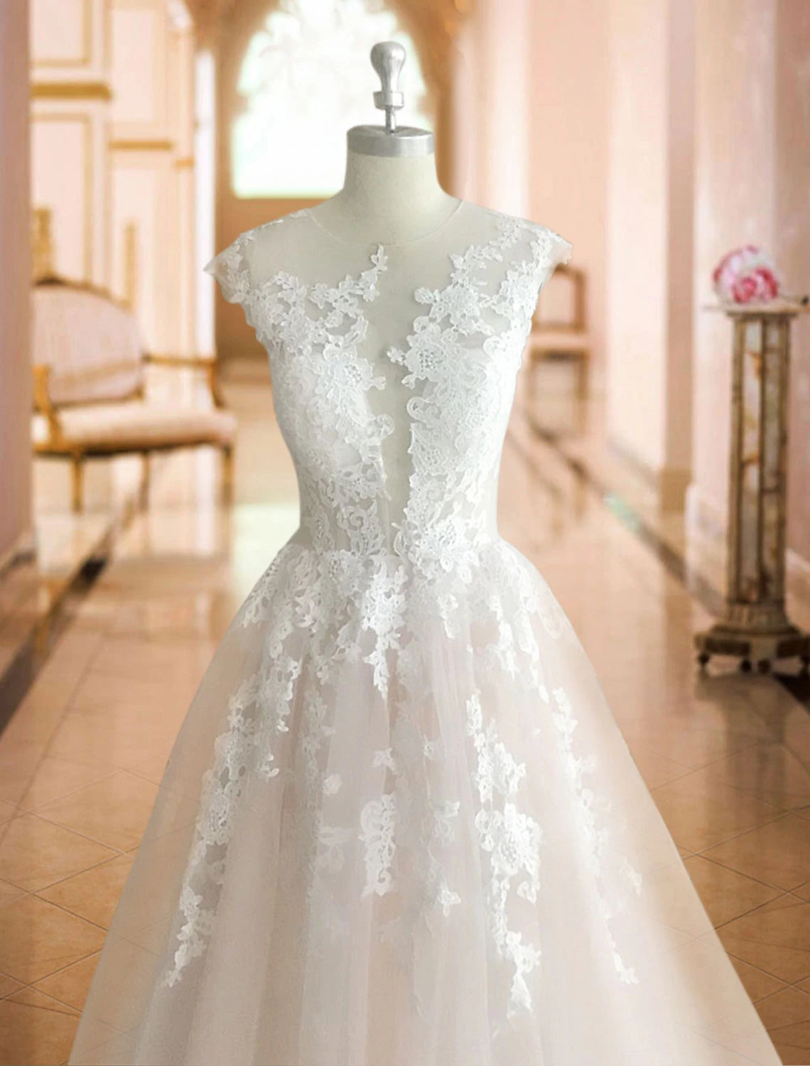 Elegant white ball gown wedding dress with illusion neck and cap sleeves.