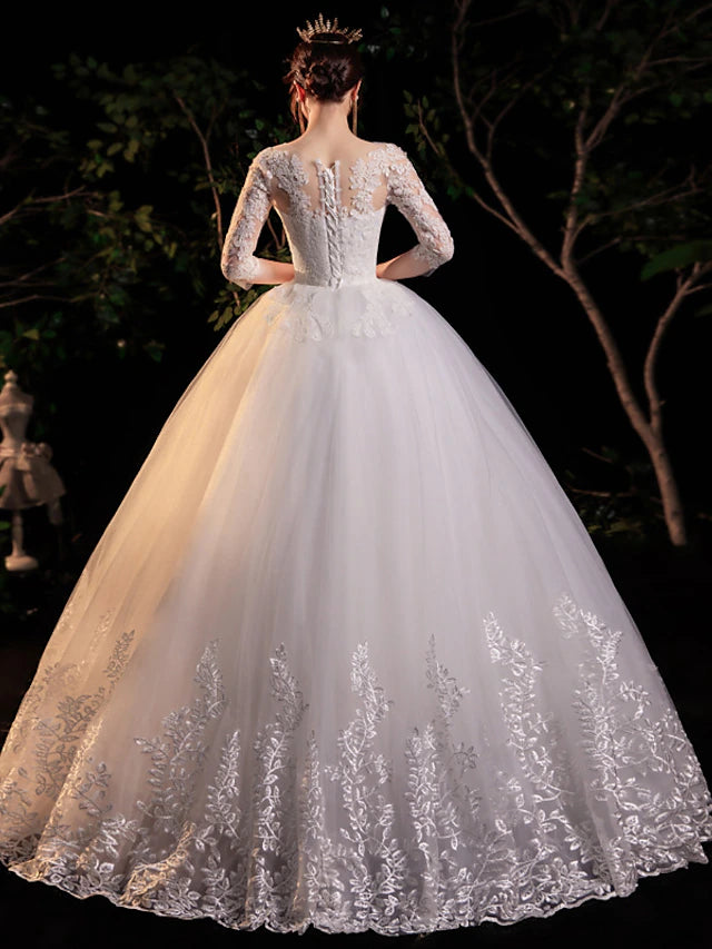 Back view of the floor-length wedding gown, showcasing intricate lace detailing and a flowing skirt.