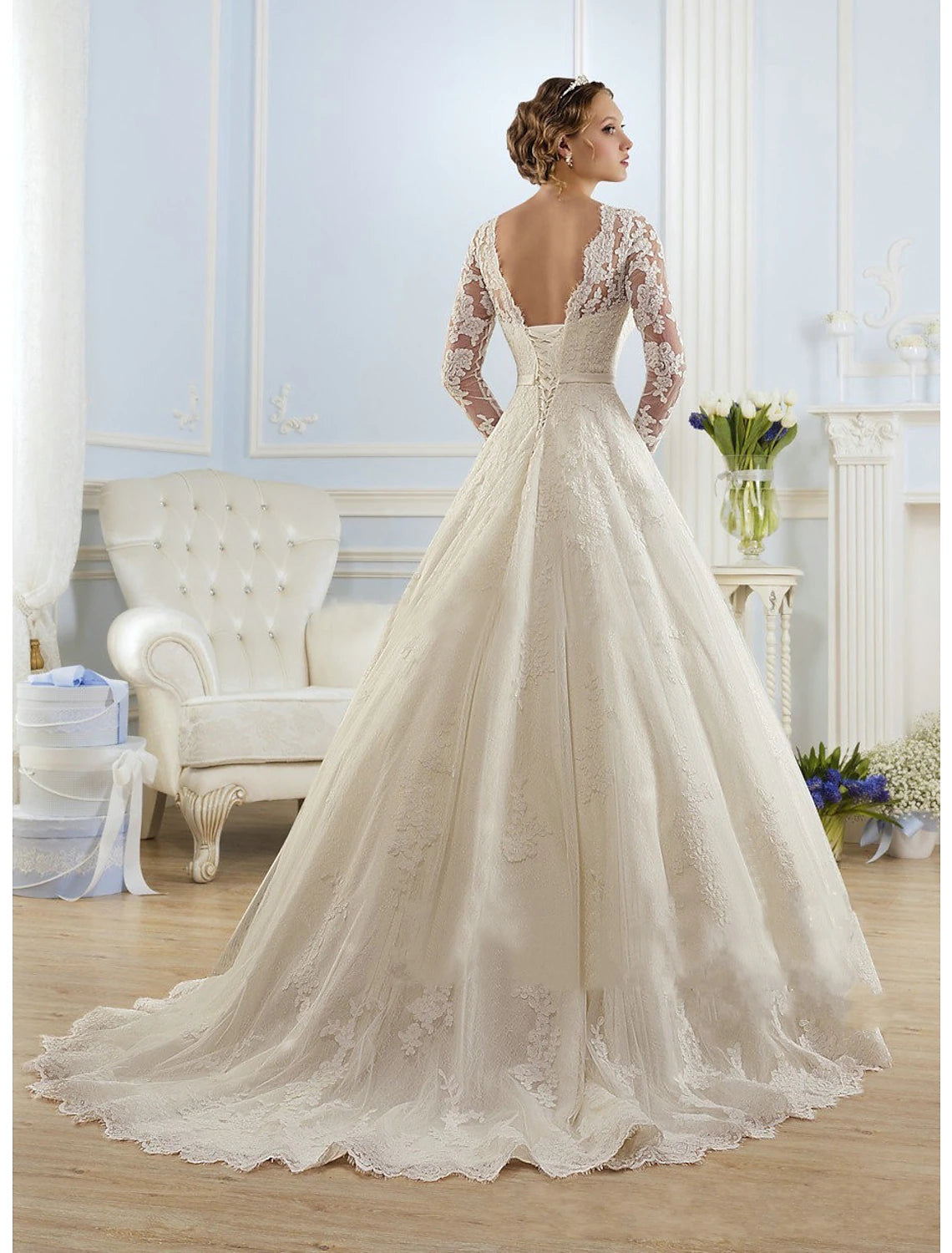 Close-up of illusion lace bodice and long sleeves on a white bridal gown.