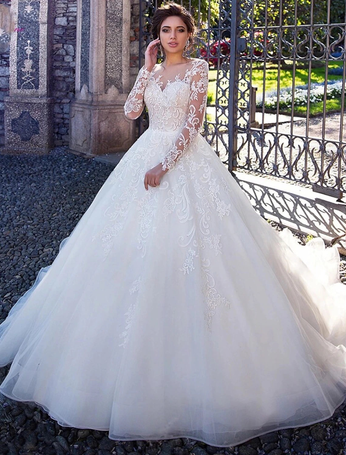 Elegant white ball gown wedding dress with illusion neckline and long sleeves.