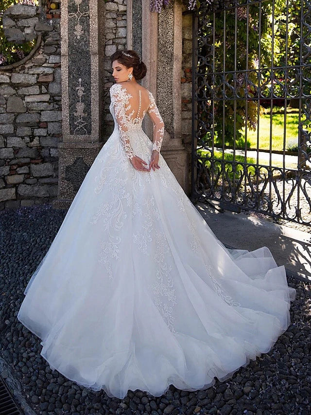 Back view of a white ball gown wedding dress, showcasing lace appliques and a flowing court train.
