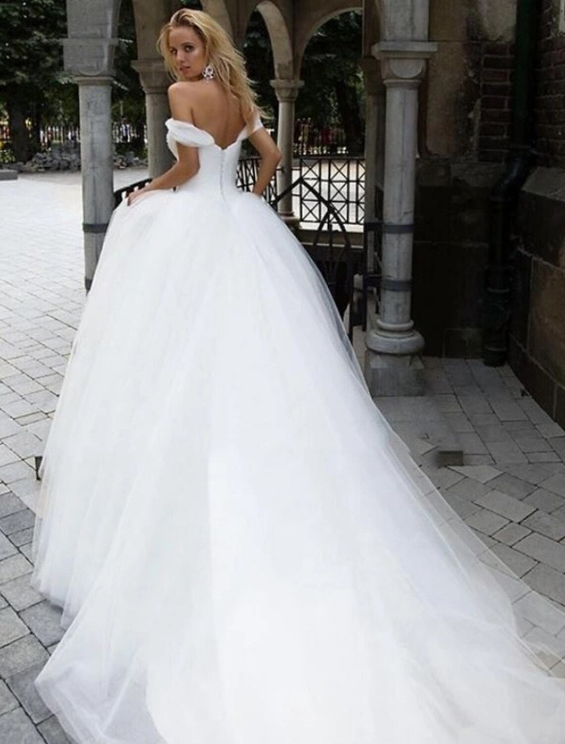 Elegant white tulle ball gown wedding dress with off-shoulder neckline and cap sleeves.