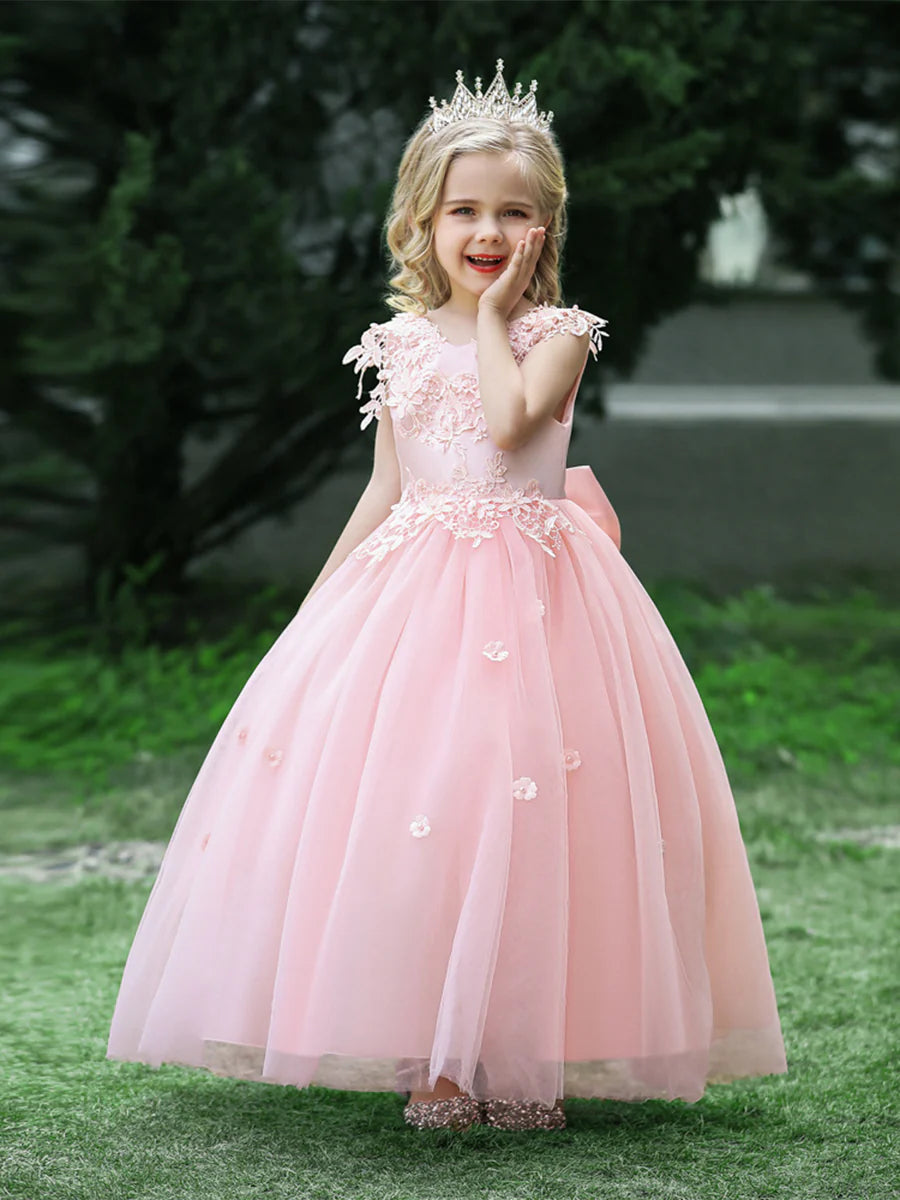 Flower girl in an elegant white ball gown with scoop neck and appliques.