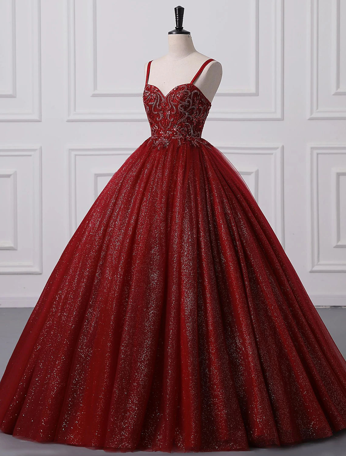 Elegant ball gown with spaghetti straps, lace, and beading for special occasions.