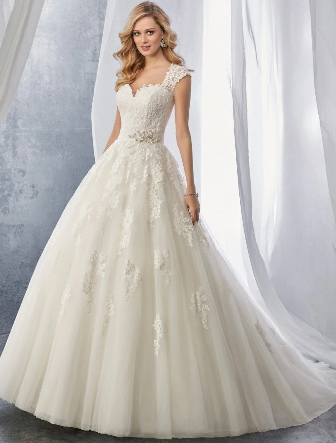 Elegant ball gown wedding dress with sweetheart neckline and cap sleeves.