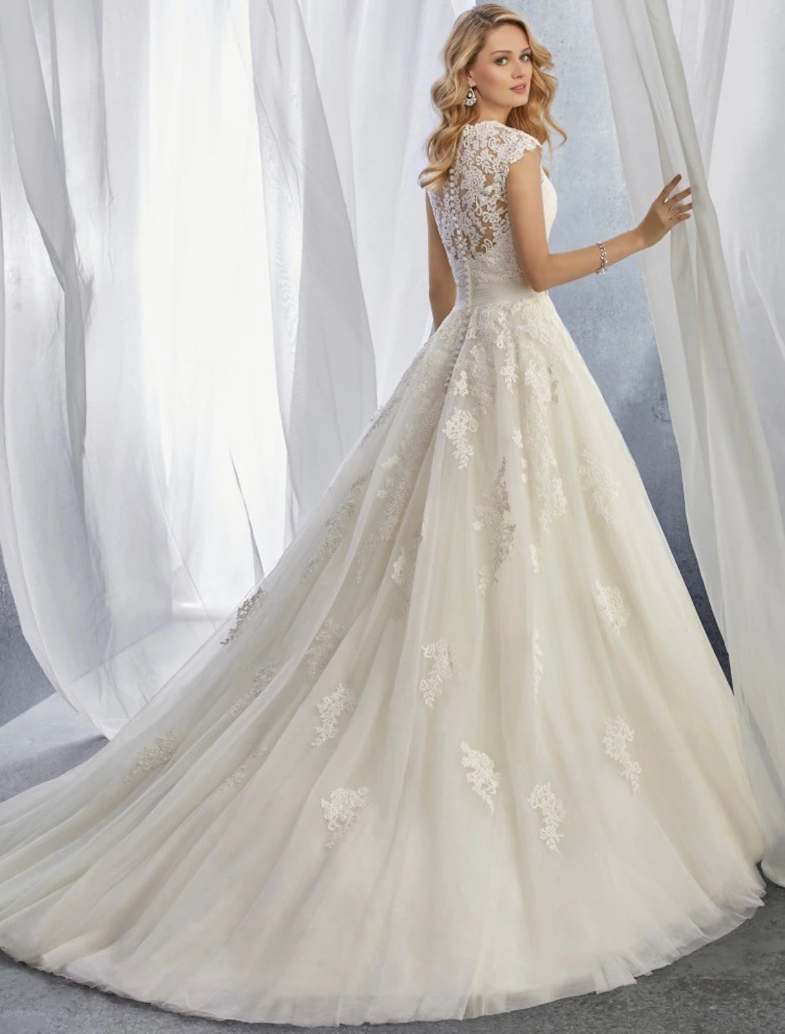Close-up of lace appliques and cap sleeve on a bridal gown.