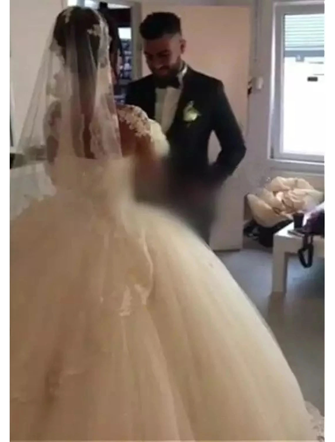 Back view of the floor-length ball gown wedding dress with lace accents.