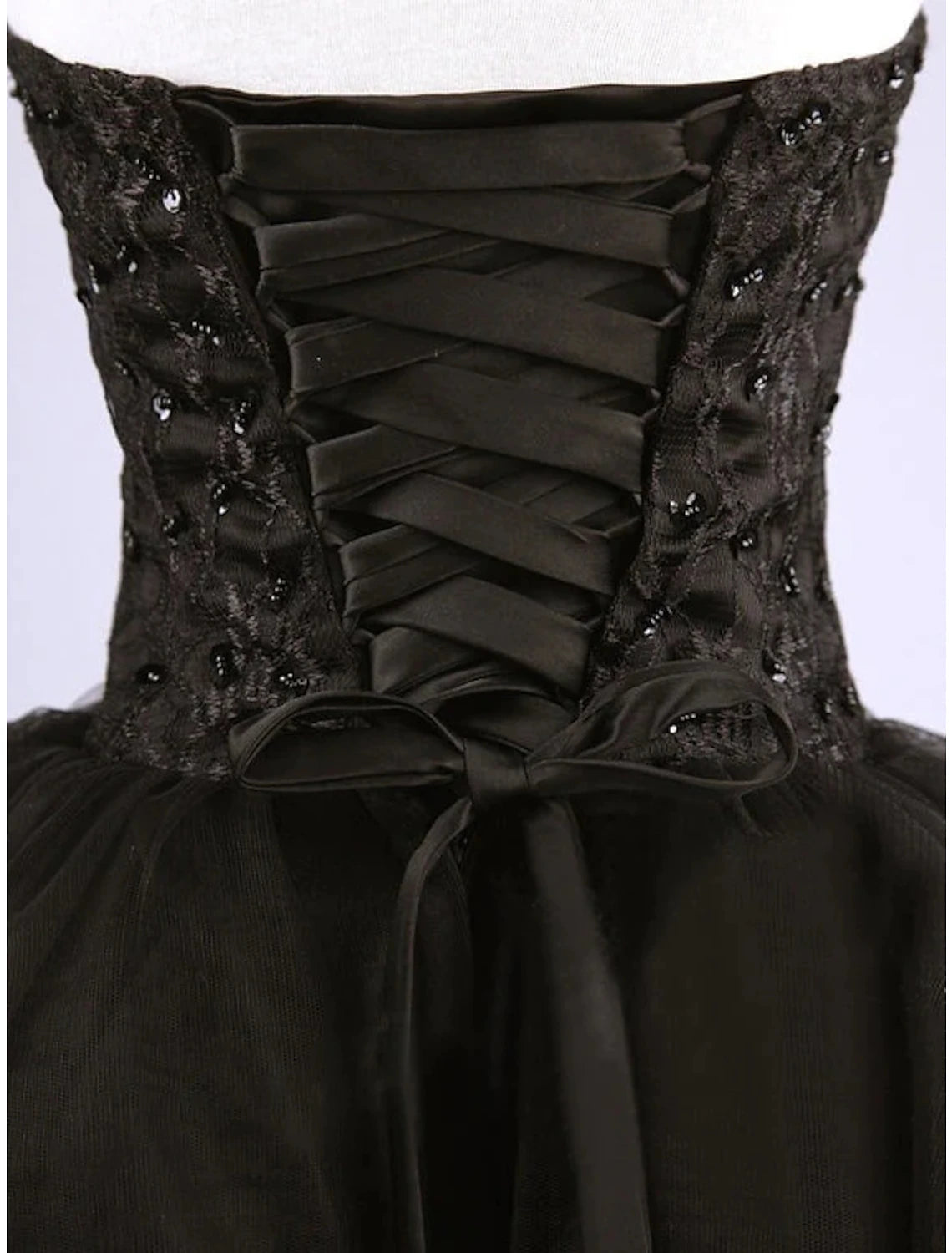 Side view of a pleated and beaded sweetheart cocktail dress.