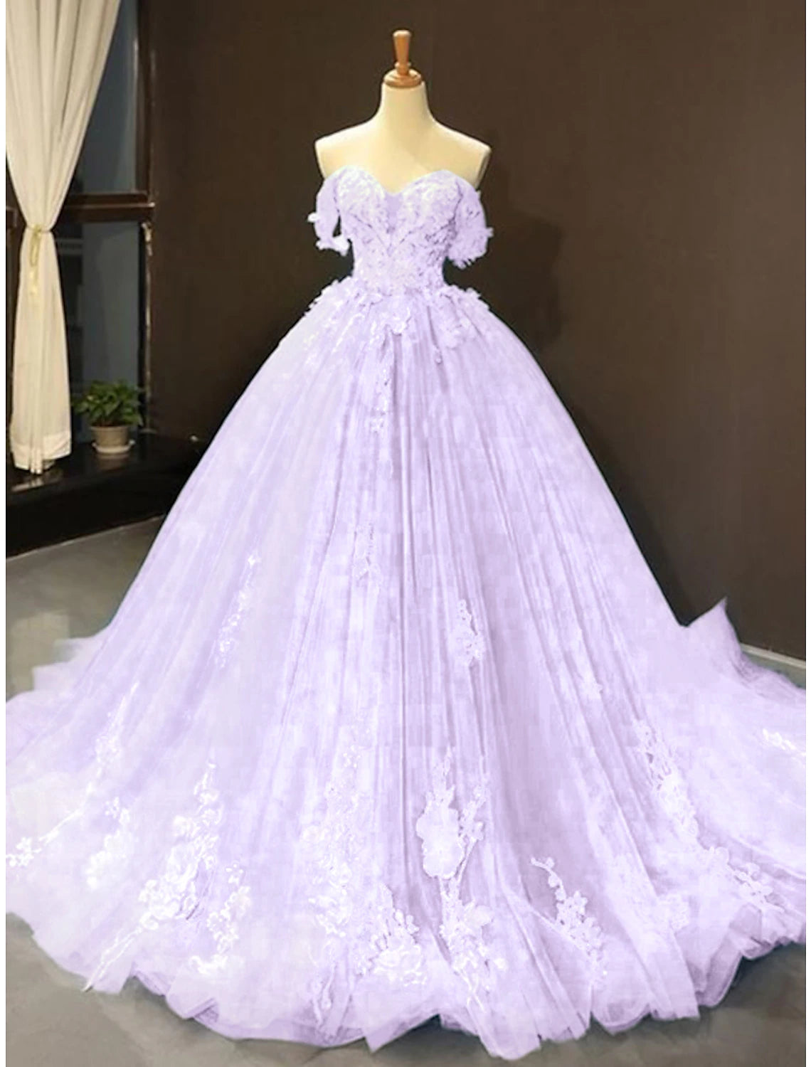 Side view of a floral lace ball gown with a court train.